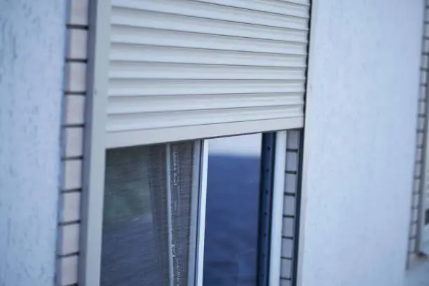 Window with half-closed roller shutter, closeup