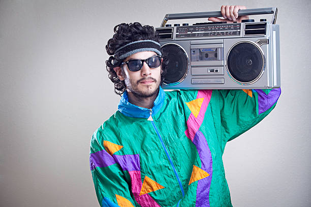 Mullet Man With 1980's-1990's Fashion Style A cool, funky young hipster adult from the late 20th century complete with mullet, boom box "ghetto blaster" stereo, fluorescent track suit, and tinted sun glasses.  Horizontal with copy space. personal stereo stock pictures, royalty-free photos & images