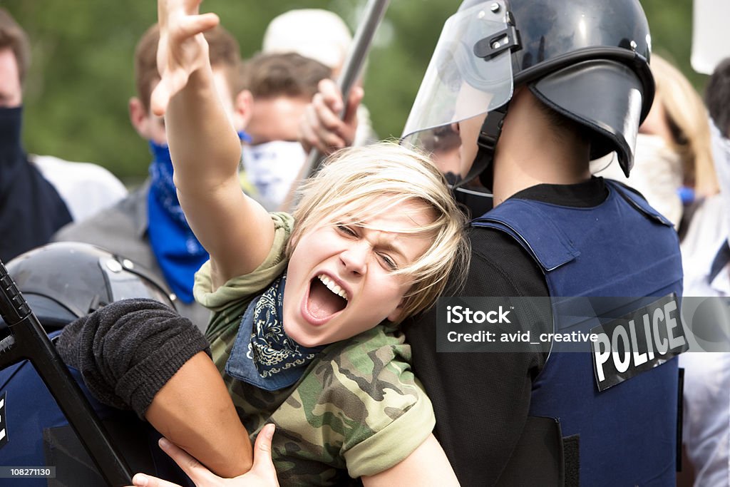Manifestante cercando di superare la polizia Barricade - Foto stock royalty-free di Dimostrazione di protesta