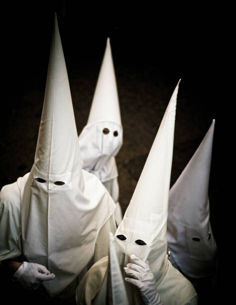 nazarenos parade during the celebration of semana santa (holy week) in sevilla, spain.  - the hat is called a Capirote.
