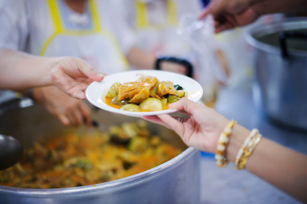 istock Hand offered to donate food from a rich man Share : Feeding Concepts 1082712546