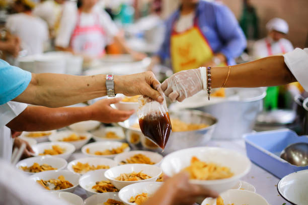 istock Hand offered to donate food from a rich man Share : Feeding Concepts 1082712608