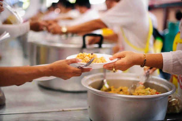 istock Hand offered to donate food from a rich man Share : Feeding Concepts 1082712662