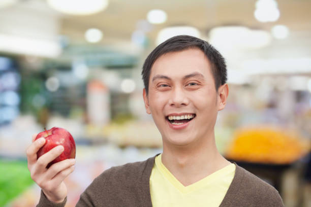 istock Chinese man holding red apple 1082713186
