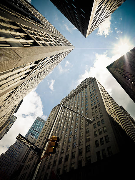 Sun over the highrise buildings at the Wall Street financial district in New York City. 'Exchange Place' Street Sign in the foreground. Hasselblad H3D-II 50 MPixel.