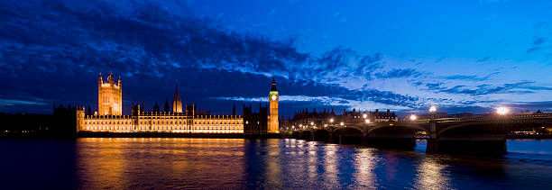 istock London's Big Ben tower glows against a dark, cloudy sky.  108271436
