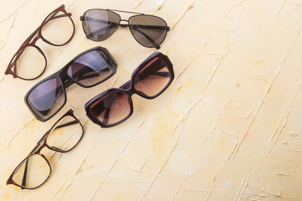 istock Various sunglasses set on yellow wooden background. 1082715256