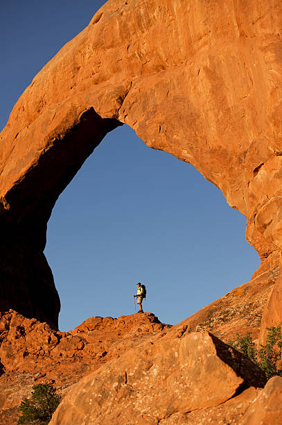 istock Backpacker Standing On Rock Under Huge Arch In Utah 108271714