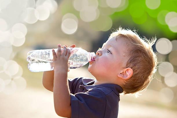 bela loiro criança beber água ao ar livre - water bottle water bottle drinking imagens e fotografias de stock