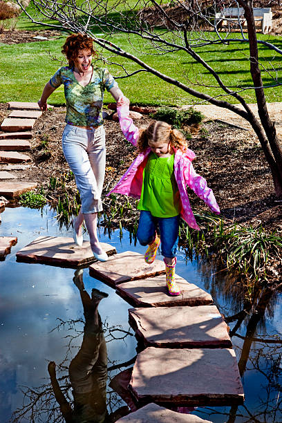 A 5 year old child in pink shirt and her reflection in fountain