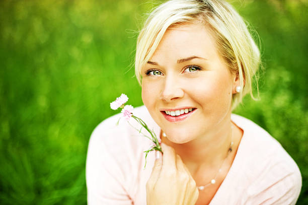 Beautiful Asian woman is smiling and relaxing in blooming purple Murdannia giganteum flowers field