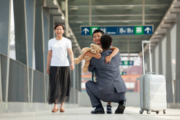uomo d'affari cinese saluta figlio su banchina treno - relazione daffari foto e immagini stock