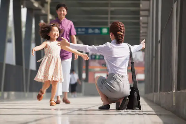 Chinese businesswoman greeting daughter on train platform