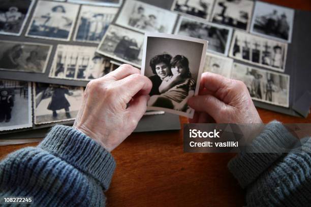 Elderly Hands Looking At Old Photos Of Self And Family Stock Photo - Download Image Now