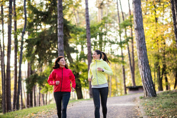 istock Two female runners jogging outdoors in forest in autumn nature. 1082724366