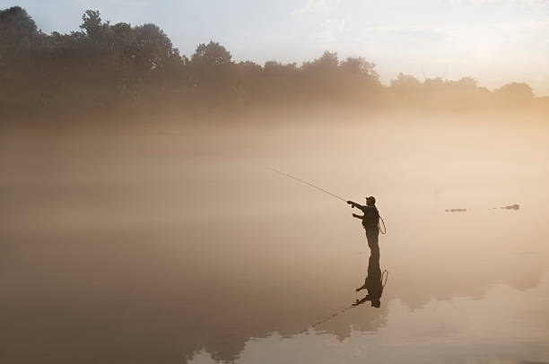 flyfisherman im nebel - fly fishing stock-fotos und bilder