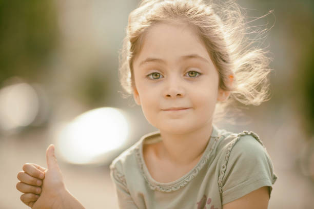 retrato de una niña de 6 años en el parque en un día soleado - 6 7 years lifestyles nature horizontal fotografías e imágenes de stock