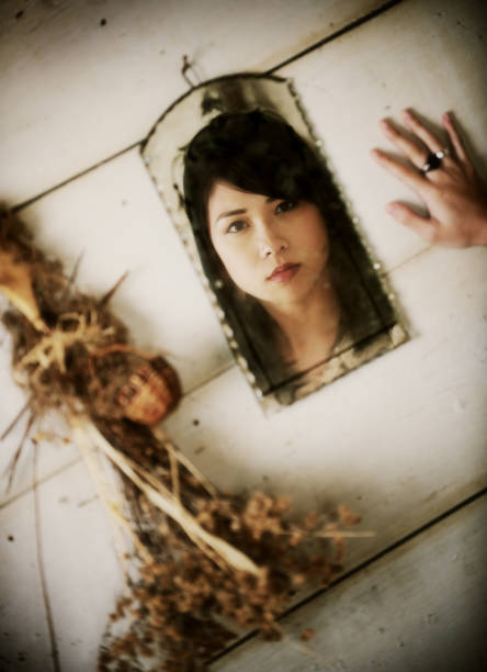 Photo of a readymade consisting of two antique porcelain doll heads and a butterfly. The background is an old handmade paper. The photo is alienated by an overlaid plane consisting of tin cans.