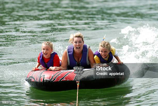 Twins With Mom Riding Tube Stock Photo - Download Image Now - Sailing, Lake, Family