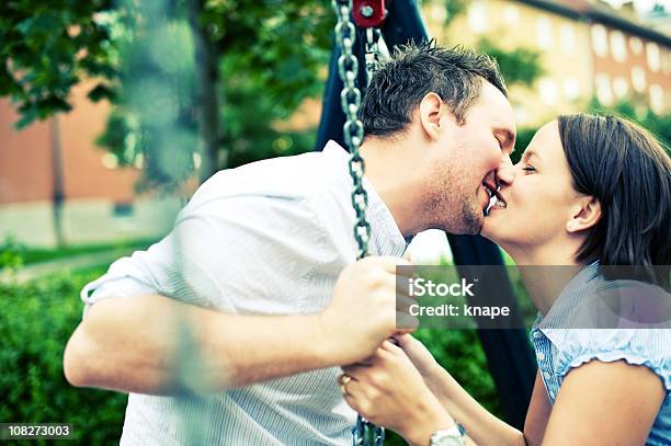Coppia Felice Baciare Su Un Altalena - Fotografie stock e altre immagini di 20-24 anni - 20-24 anni, 25-29 anni, Abbracciare una persona