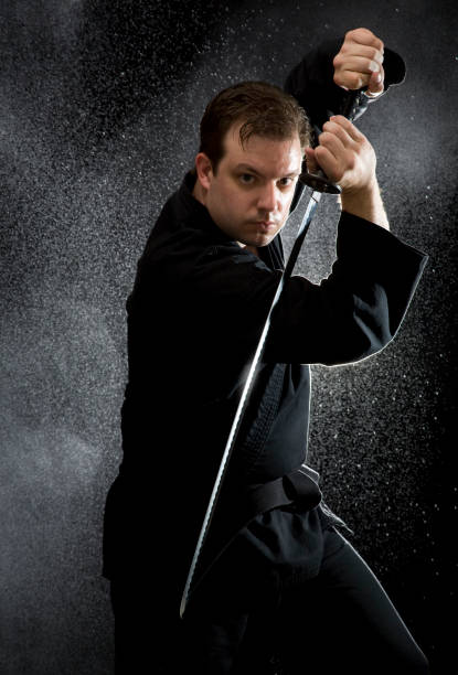 istock Man Wearing Black Karate Suit and Holding Sword 108273174