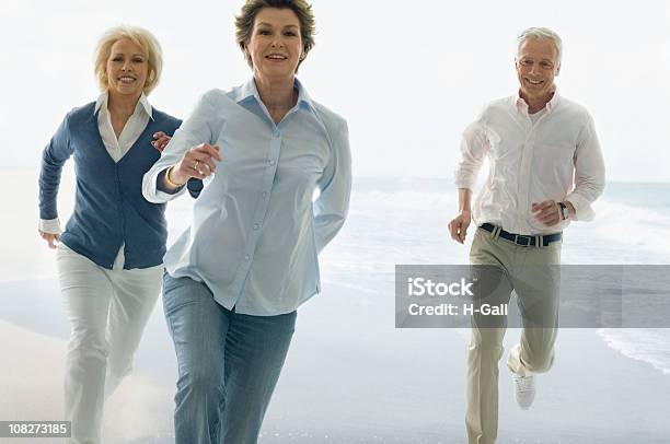 Three Seniors Running On Beach Stock Photo - Download Image Now - Healthy Lifestyle, Beach, Running