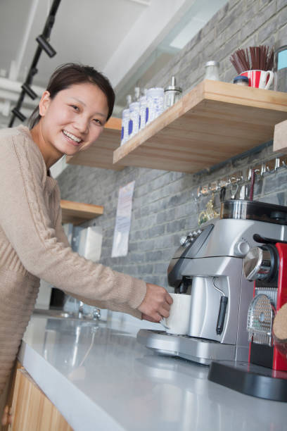 istock Chinese woman making coffee in office kitchen 1082732164