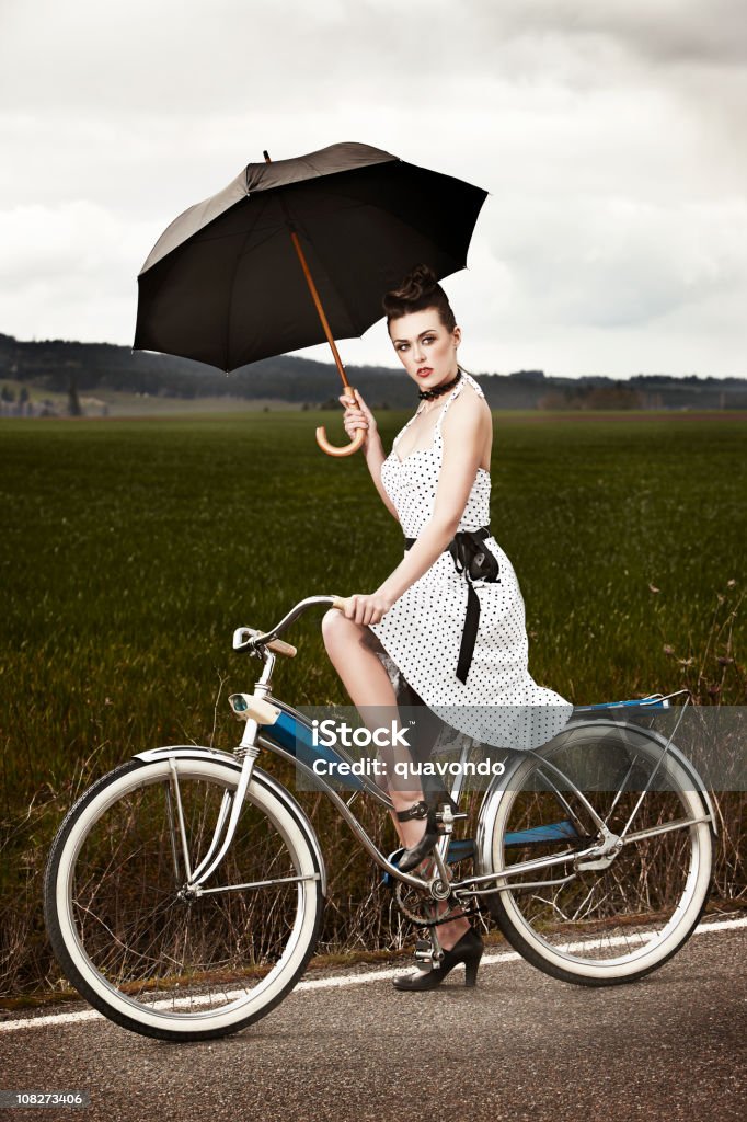Brunette Moda Model na rower Trzymając parasol, miejsce na tekst - Zbiór zdjęć royalty-free (Bicykl)