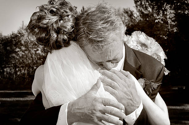 Emotional Father Of The Bride Giving His Daughter A Hug Father of the Bride Full of Emotion As He Hugs His Little Girl One Last Time Before She Marries. Back Of Bride. Front of Father. Father Crying. Right Hand Showing Some Movement as he pats her on the back. bride hugging father on wedding day stock pictures, royalty-free photos & images