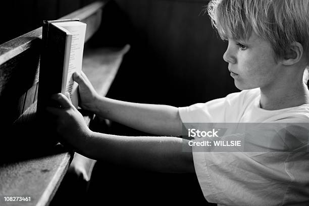 Tranquil Scene Of Child In Church Reading Prayer Book Stock Photo - Download Image Now