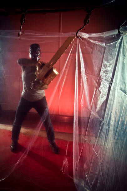 Man Wielding Chain Saw in Plastic Covered Room