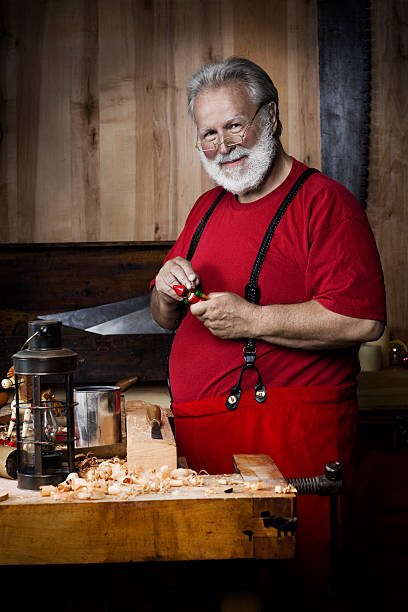 alegre santa claus en taller de pintura juguete, espacio de copia - workshop santa claus christmas north pole fotografías e imágenes de stock