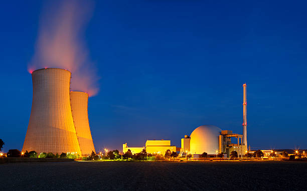 centrale nucleare con un cielo blu notte - nuclear energy foto e immagini stock