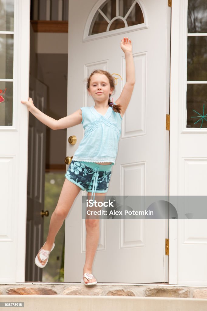 Una niña darle alguien en su puerta frontal - Foto de stock de Casa libre de derechos