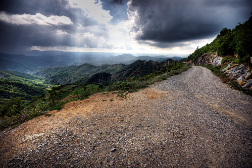 View down a dirt road in the Albanian mountains with storm clouds approaching. Multiple exposures used for high dynamic range. Contrast increased in post processing.\n\nPlease see my related collections...\n\n[url=search/lightbox/7431206][img]http://i161.photobucket.com/albums/t218/dave9296/Lightbox_Vetta.jpg[/img][/url]\n\n[url=search/lightbox/4703719][img]http://i161.photobucket.com/albums/t218/dave9296/Lightbox_maj_alps1-V2.jpg[/img][/url]\n[url=search/lightbox/6710118][img]http://i161.photobucket.com/albums/t218/dave9296/Lightbox_Albania-V2.jpg[/img][/url]\n[url=search/lightbox/4719824][img]http://i161.photobucket.com/albums/t218/dave9296/Lightbox_travelers-V2.jpg[/img][/url]\n[url=search/lightbox/6315481][img]http://i161.photobucket.com/albums/t218/dave9296/Lightbox_HDR2-V2.jpg[/img][/url]