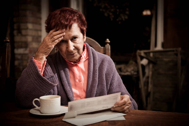 deteriorado senior mujer con facturas - women poverty senior adult mature adult fotografías e imágenes de stock