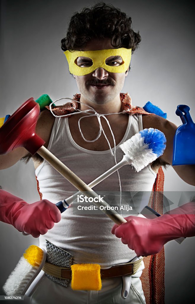 Uomo che tiene la pulizia forniture indossando maschera Supereroe - Foto stock royalty-free di Pulire
