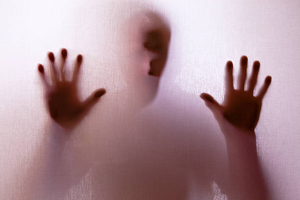 istock Creepy, man distressed, trapped behind a screen in silhouette. 108274379