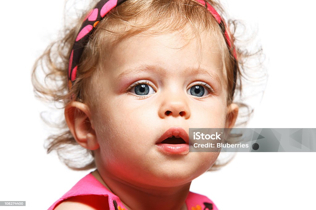 Portrait of Little Baby Girl Wearing Pink on White Background Young girl looking at the camera. Babies Only Stock Photo