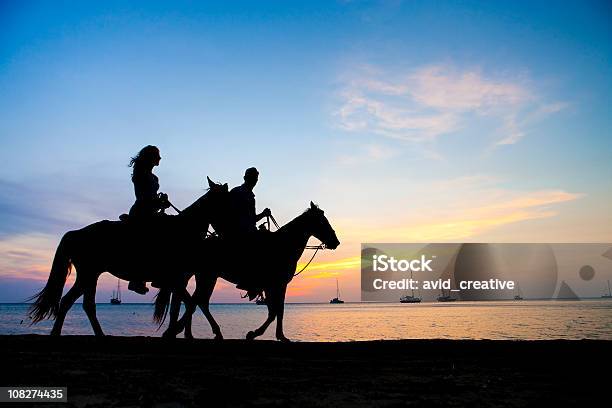 Photo libre de droit de Vacances De Style De Viecouple À Cheval Au Coucher Du Soleil banque d'images et plus d'images libres de droit de Monter à cheval