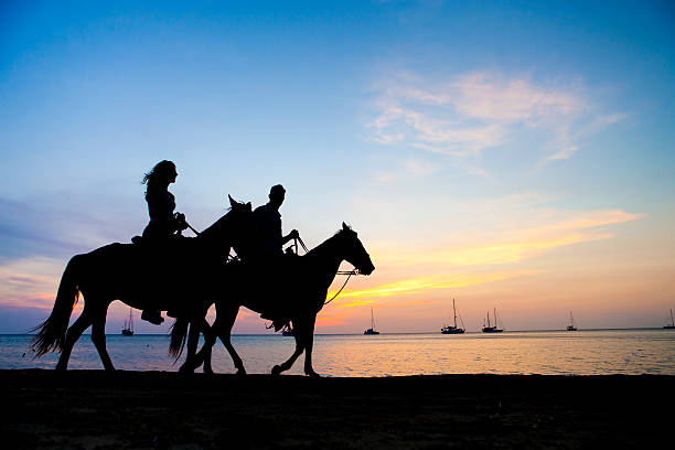 Mexican sunset near Cabo san Lucas with man and horses.