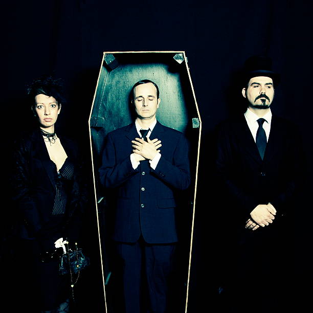 Widow, undertaker and man in coffin Widow, dead husband in coffin and undertaker. man casket stock pictures, royalty-free photos & images