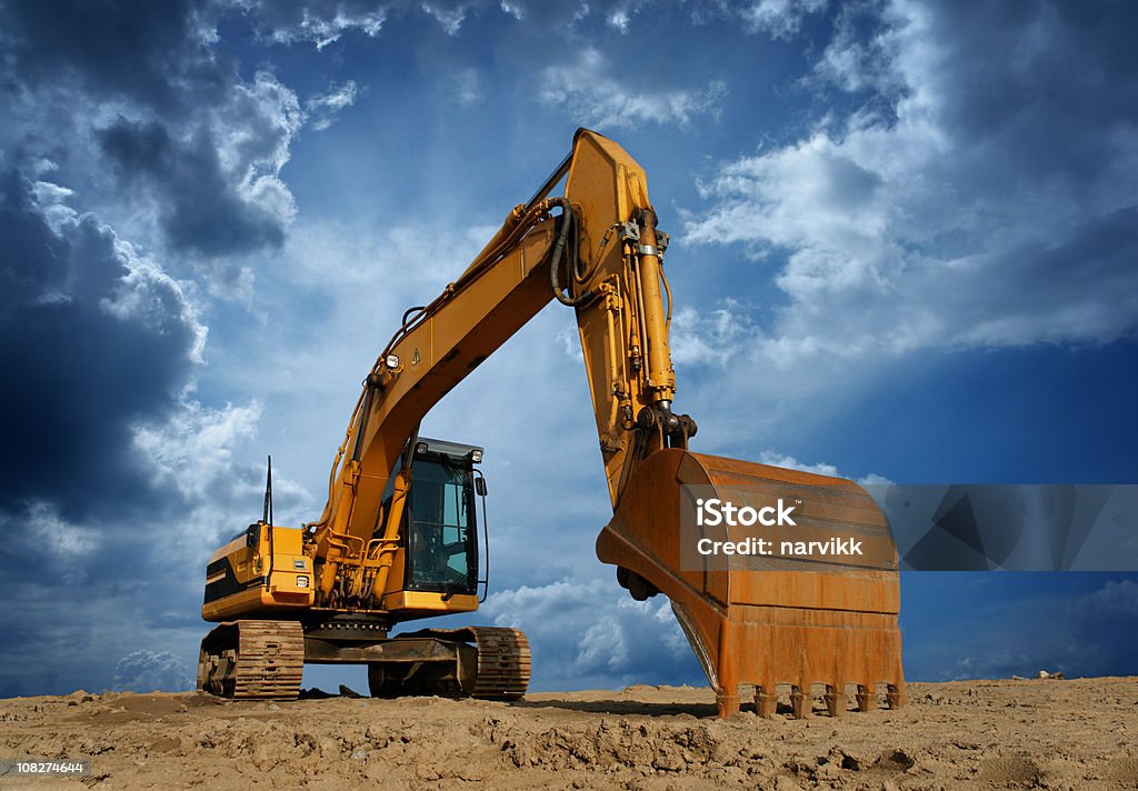 Amarillo Excavator en solar de construcción - Foto de stock de Cavadora mecánica libre de derechos