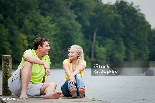 Padre E Hija Hablando Por Muelle Foto de stock y más banco de imágenes de Diálogo - Diálogo, Adolescente, Aire libre