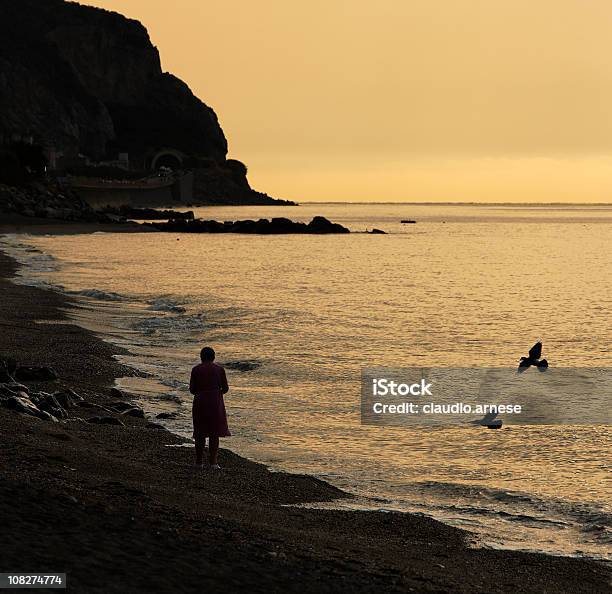 Edad Mujer Caminando En La Playa Al Atardecer Sepia Tono Foto de stock y más banco de imágenes de Aire libre