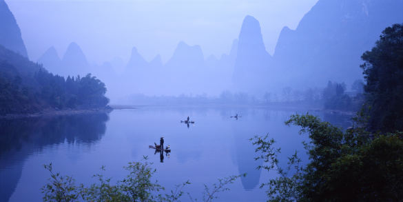 Trang An, Vietnam - 11 April 2023: Boat rowing along the Thung Chuoi temple gate between lush green karst mountains
