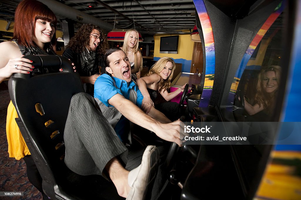 Amigos jugando en la sala de videojuegos - Foto de stock de Sala de máquinas recreativas libre de derechos