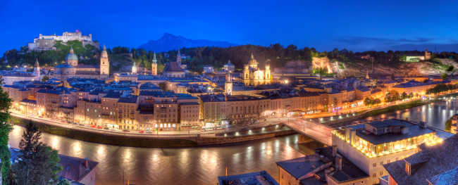 Nighttime panoramic image of Salzburg's famous old town with Alps in the background. Image is composition of 3 separate photos combined for high resolution.