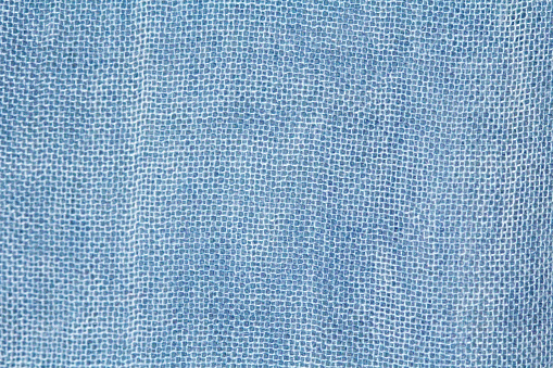 Pastel background. Background made of natural fabric. Texture of natural linen or cotton fabric. The color is denim or blue.