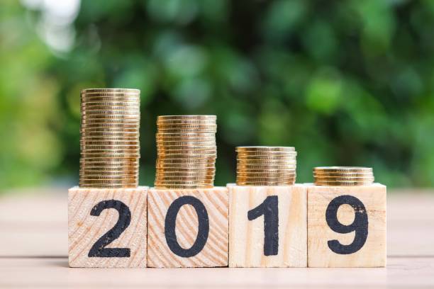 istock Growth of coins stack and wood blocks number 2019. 1082766522